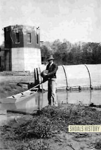 Using a knapsack-spraycan to apply Paris Green dust in front of the Malaria Control Base